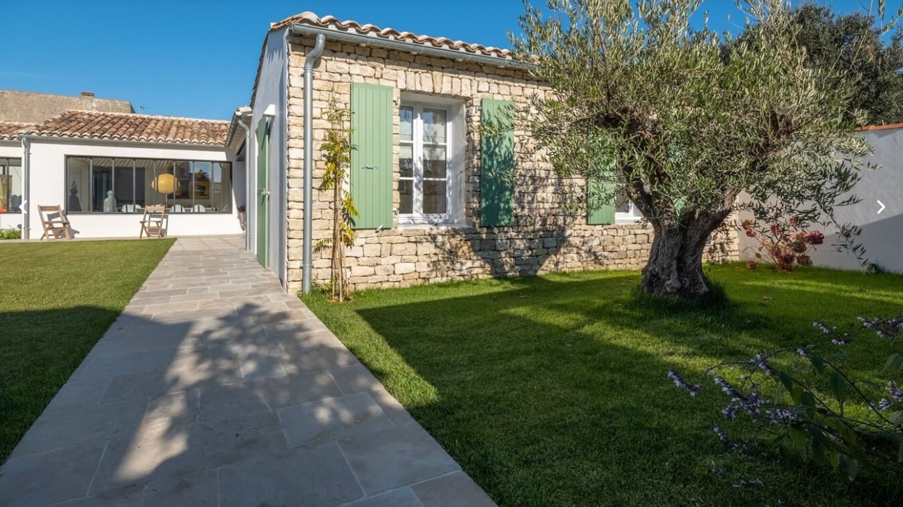 Maison blanche Île de Ré volets verts roses trémières